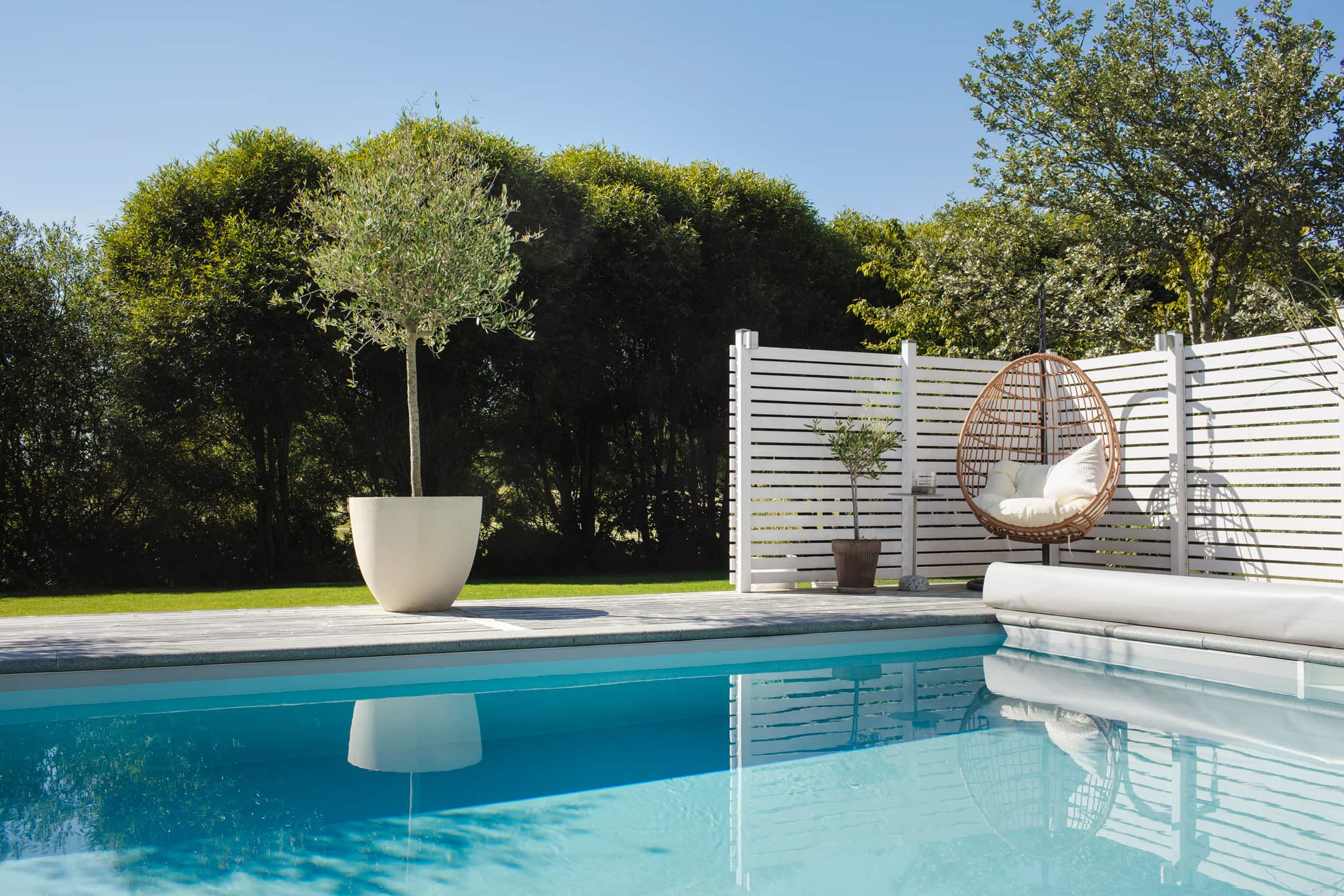Inspirerande poolmiljö med växter och solstol för den som vill bygga pool.